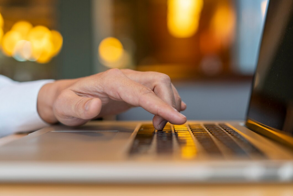 man-typing-on-laptop-with-bokeh_23-2148377731.jpg